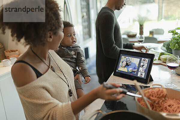 Familie kochen Abendessen und Video-Chat durch digitale Tablette in der Küche