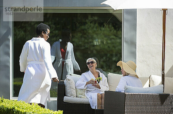 Glückliche ältere Frauen Freunde entspannen in Spa Roben auf sonnigen Hotelterrasse