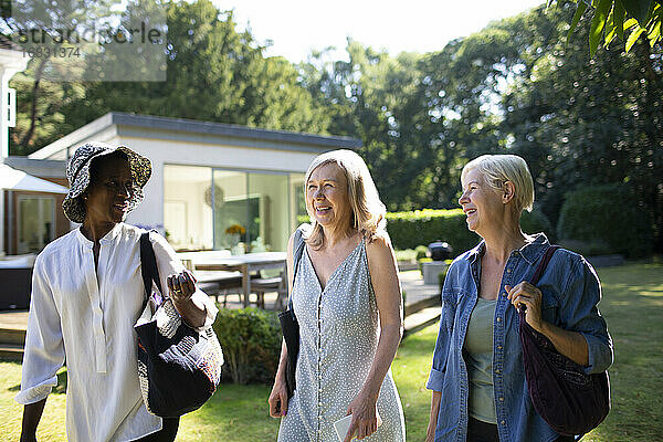 Senior Frauen Freunde zu Fuß in sonnigen Sommer Garten