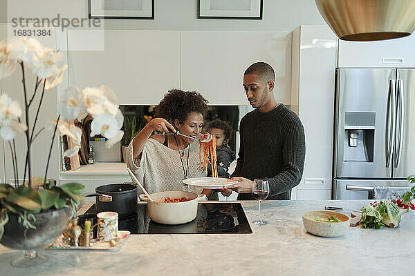 Paar mit Baby Tochter Kochen Spaghetti in der Küche