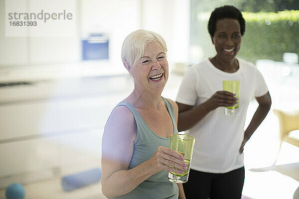 Glückliche ältere Frauen Freunde trinken Wasser nach dem Training zu Hause