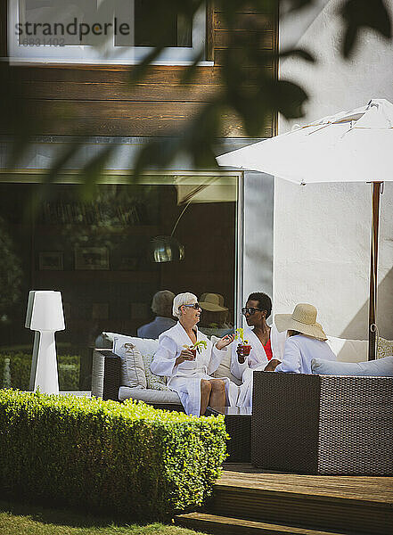 Senior Frauen Freunde entspannen in Spa Roben auf sonnigen Hotelterrasse