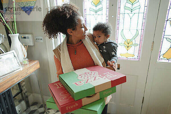 Mutter mit Baby Tochter erhalten Pizza Lieferung an der Haustür