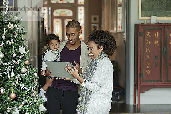 Familie beim Videochat mit digitalem Tablet am Weihnachtsbaum