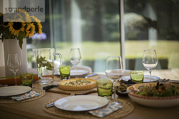 Quiche und Salat Mittagessen auf Esstisch mit Sonnenblumen