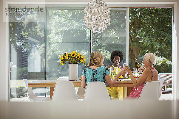 Glückliche ältere Frauen Freunde genießen das Mittagessen mit Wein am Esstisch