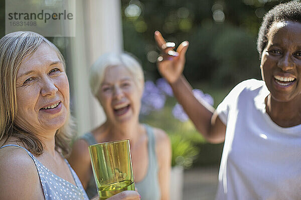 Porträt glücklich Senior Frauen Freunde lachen auf sonnigen Terrasse
