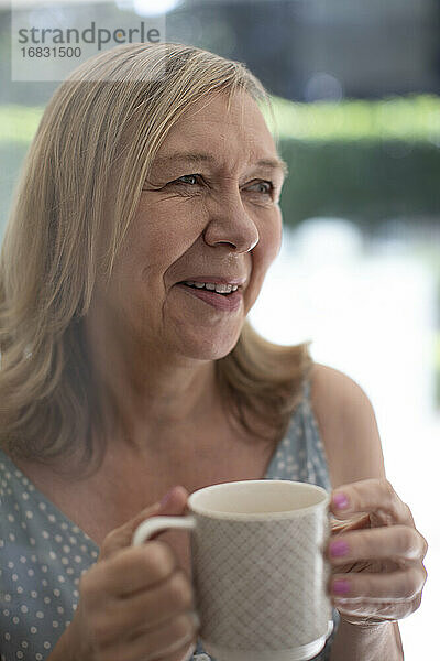Glückliche ältere Frau trinkt Tee