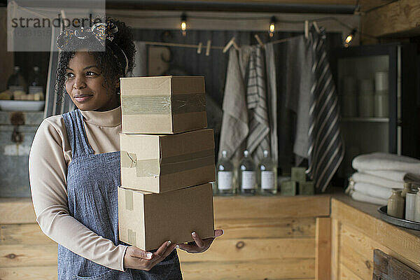 Porträt zuversichtlich weiblichen Ladenbesitzer mit Stapel von Kartons