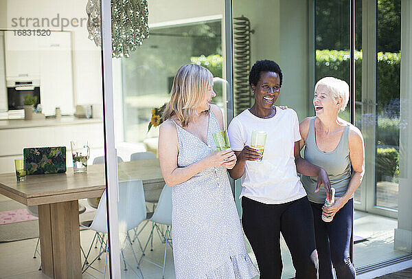Glückliche ältere Frauen Freunde trinken und lachen auf sonnigen Terrasse