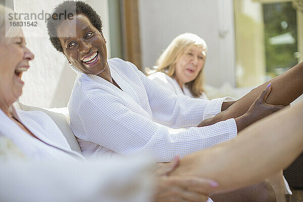 Playful Senior Frauen Freunde in Spa-Bademäntel auf Hotel-Terrasse