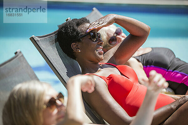 Glückliche ältere Frauen Freunde Sonnenbaden bei sonnigen Sommer poolside