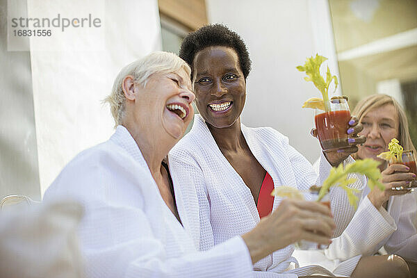 Glückliche Seniorinnen genießen Bloody-Mary-Cocktails