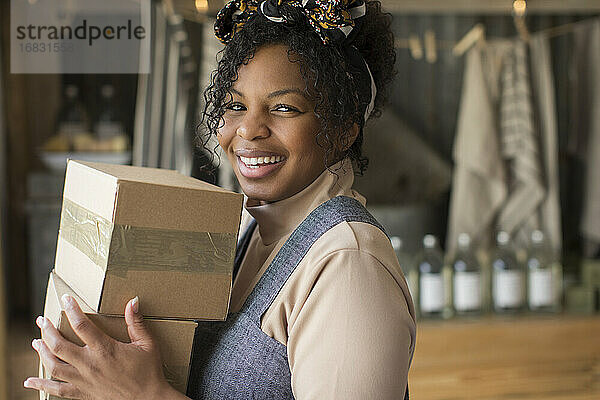 Porträt glücklich zuversichtlich weiblichen Ladenbesitzer mit Kartons