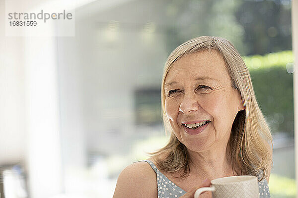 Porträt glückliche ältere Frau trinkt Tee zu Hause