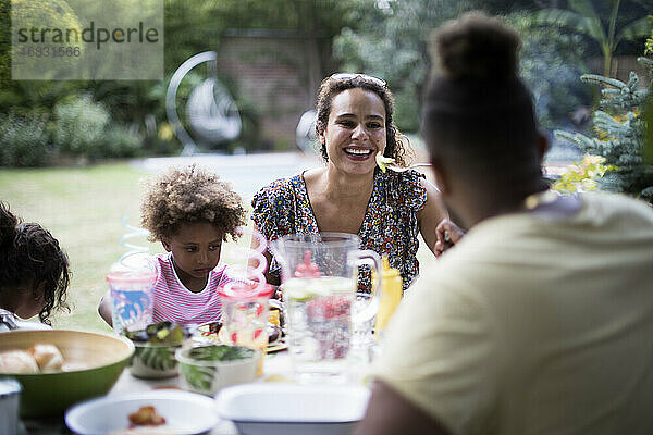 Glückliche Familie genießt das Mittagessen auf der Sommerterrasse