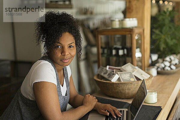 Porträt selbstbewusste Ladenbesitzerin mit Laptop in der Gärtnerei