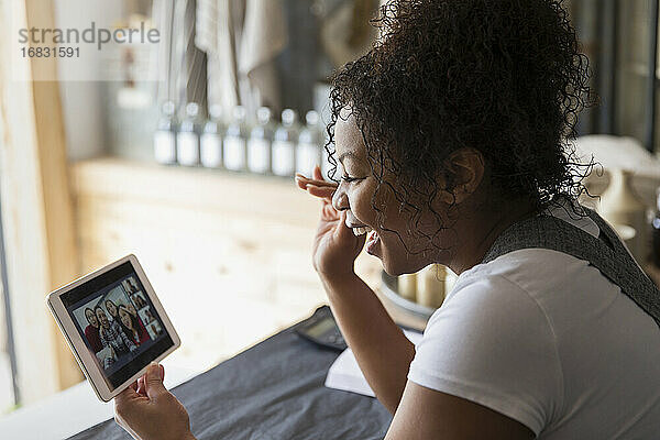 Weiblicher Ladenbesitzer Video-Chat mit Familie auf digitalem Tablet