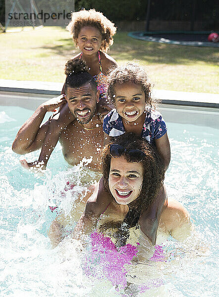 Porträt glückliche Familie Planschen in sonnigen Sommer Schwimmbad