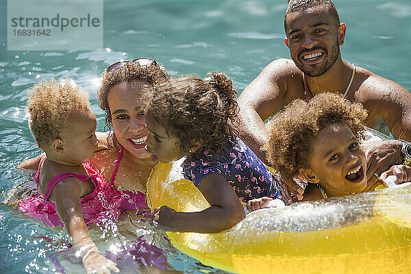 Porträt glückliche Familie spielen in sonnigen Sommer Schwimmbad