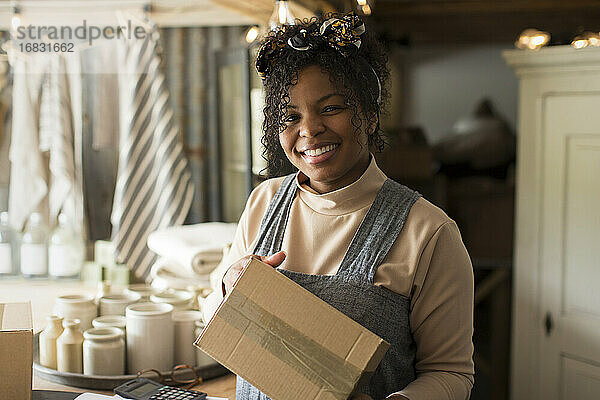 Porträt glückliche weibliche Ladenbesitzerin mit Paket