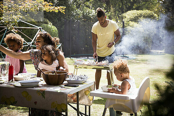 Familie Grillen und Essen auf sonnigen Sommer Hinterhof Terrasse