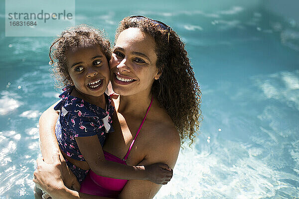 Porträt glücklich Mutter und Tochter in sonnigen Sommer Schwimmbad