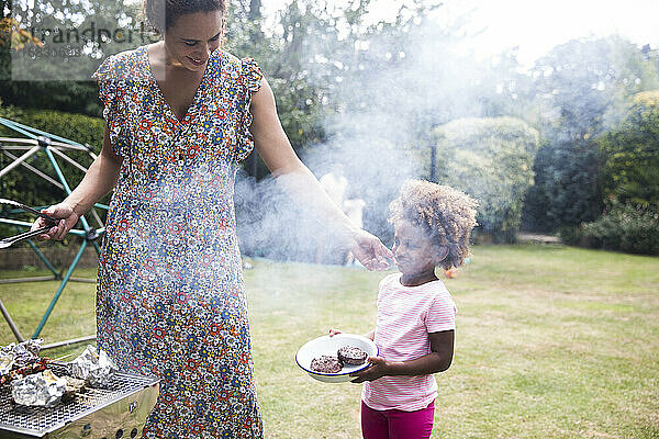 Mutter und Tochter beim Grillen im Sommer Hinterhof