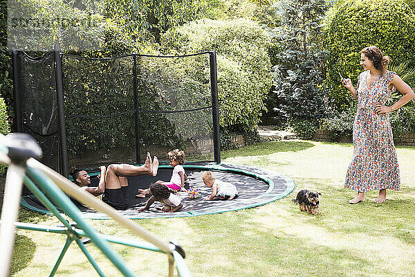 Familie spielt auf sonnigen Hinterhof Trampolin