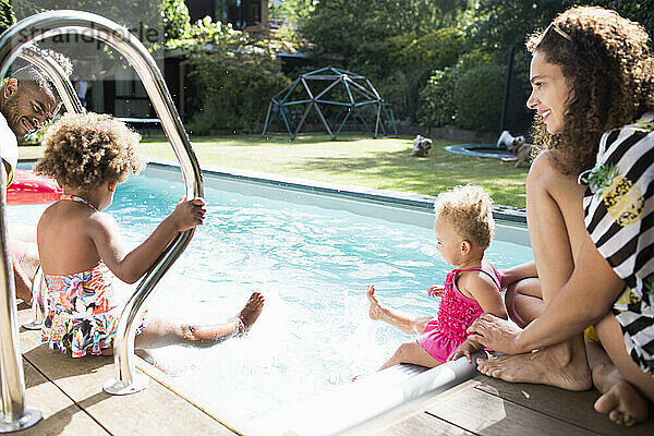 Glückliche Familie entspannt und planscht im sonnigen Sommer Schwimmbad