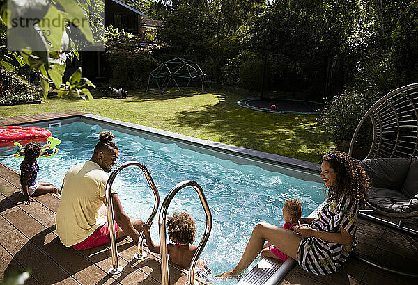 Glückliche Familie entspannt am sonnigen Sommer Poolside Terrasse