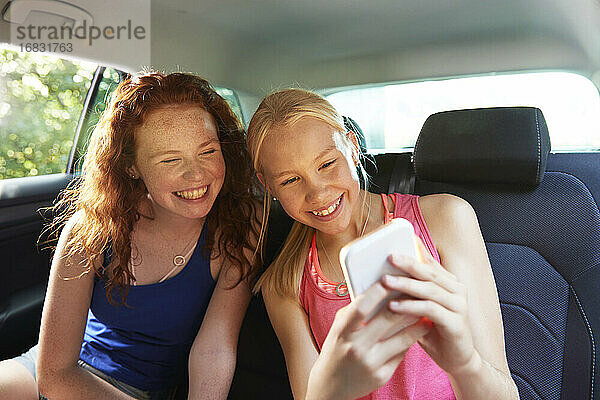 Glücklich preteen Mädchen Freunde nehmen selfie auf dem Rücksitz des Autos