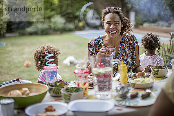 Porträt glückliche Mutter genießt Sommer Barbecue mit Familie auf der Terrasse