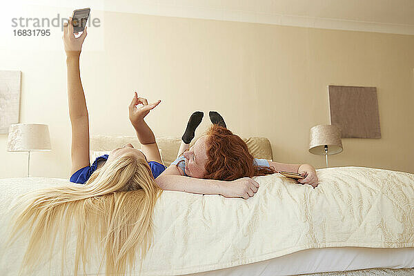 Sorglos preteen Mädchen Freunde nehmen selfie auf Bett