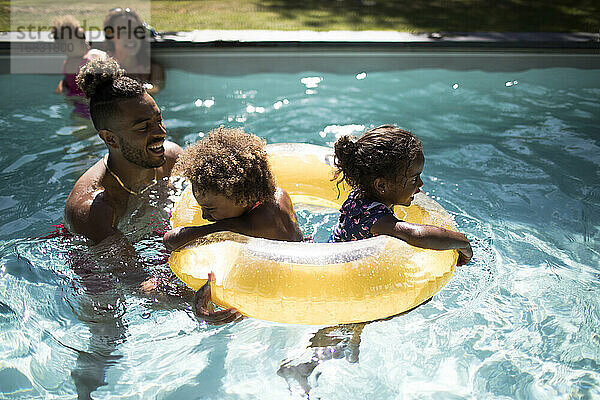 Familie spielt mit aufblasbaren Ring in sonnigen Sommer Schwimmbad