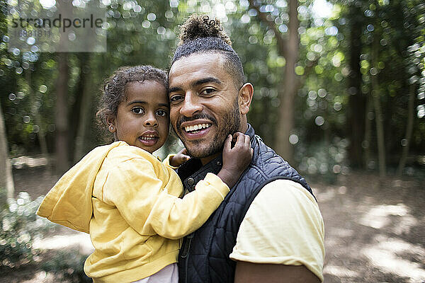 Portrait glücklicher Vater und Tochter im Wald