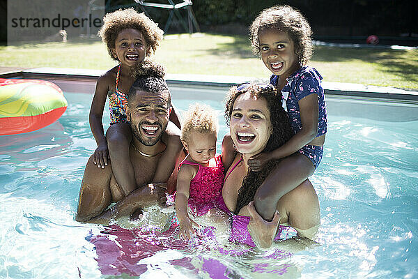 Porträt glücklich aufgeregt Familie spielen in sonnigen Sommer Schwimmbad