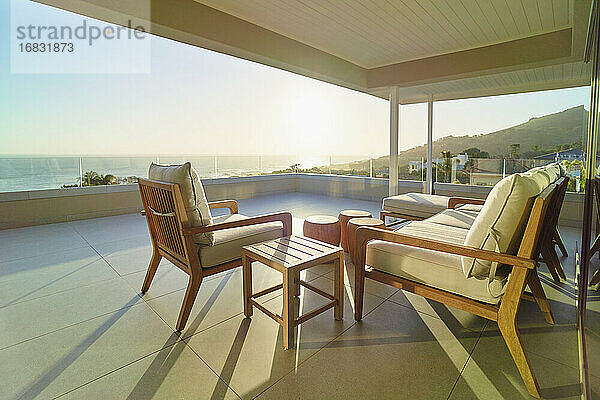 Sofa und Sessel auf sonniger  ruhiger Luxus-Terrasse mit Meerblick