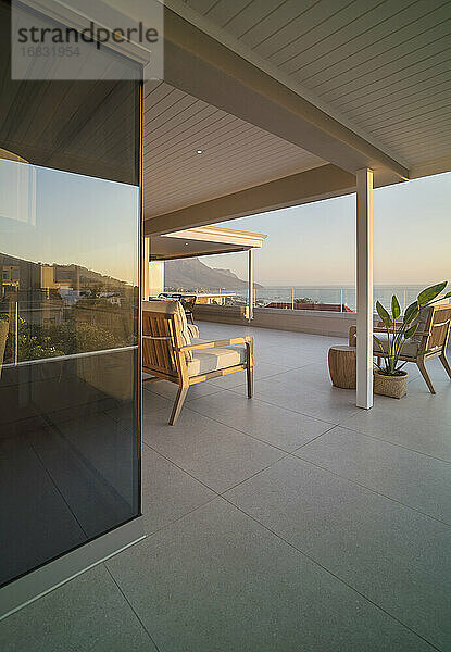 Sessel auf sonniger Luxus-Terrasse mit Meerblick