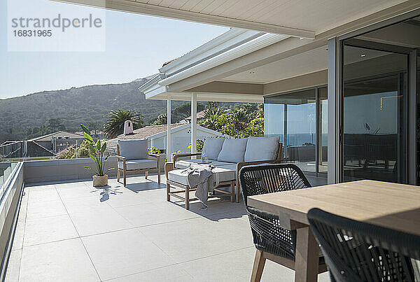 Esstisch und Sofa auf der sonnigen Home-Showcase-Terrasse