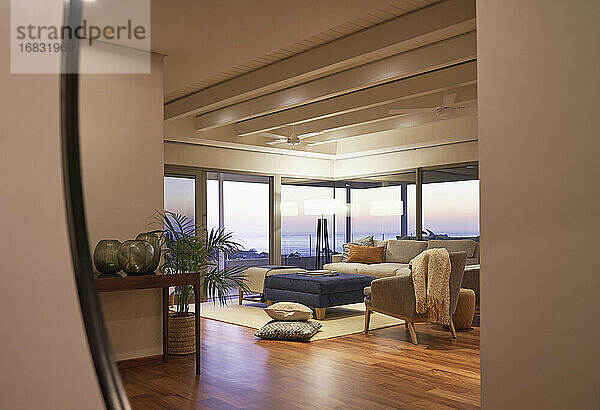 Reflexion von Luxus Hause Showcase Wohnzimmer mit Blick auf das Meer bei Sonnenuntergang