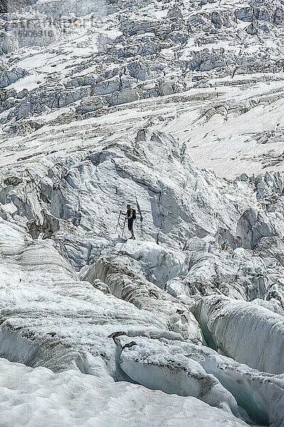 Bergsteiger steht auf zerfurchtem Gletscher  Gletschereis mit Gletscherspalten  Gletscherzunge  Glacier des Bossons  La Jonction  Chamonix  Haute-Savoie  Frankreich  Europa