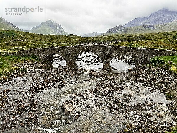 Alte Steinbrücke Sligachan Bridge vor den Cuillin Hills Gebirge  schwere Regenwolken  Sligachan  Portree  Isle of Skye  Innere Hebriden  Schottland  Großbritannien  Europa