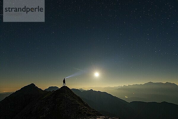 Bergsteiger auf Gipfelgrat mit Vollmond und Sternenhimmel  im Hintergrund Ammergauer Alpen  Reutte  Ammergauer Alpen  Tirol  Österreich  Europa