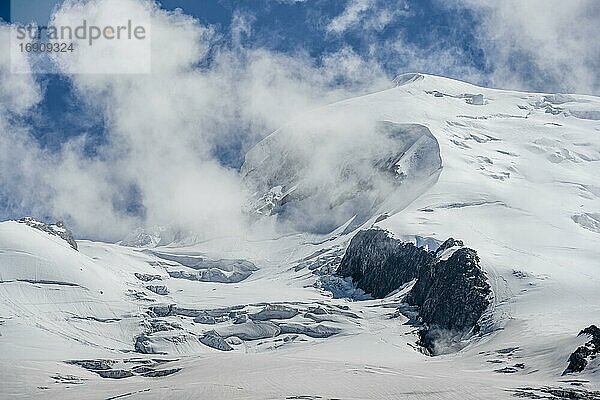 Hochalpine Berglandschaft  Wolken am Gipfel Dôme du Goûter mit Gletscher  Chamonix  Haute-Savoie  Frankreich  Europa