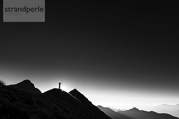 Bergsteiger auf Gipfelgrat bei Gegenlicht  im Hintergrund Ammergauer Alpen  Reutte  Ammergauer Alpen  Tirol  Österreich  Europa