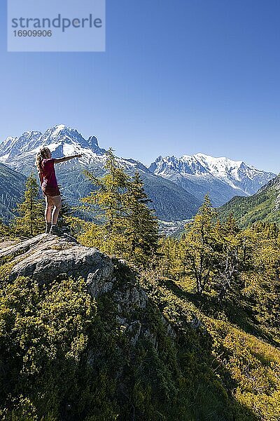 Wanderin zeigt auf Bergpanorama  Blick von Aiguillette des Posettes  Gipfel Aiguille Verte  Aiguille du Midi und Mont Blanc  Chamonix  Haute-Savoie  Frankreich  Europa