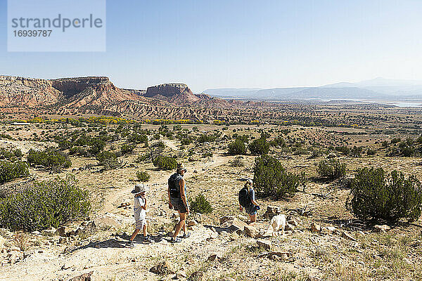 Drei Personen  Familie beim Wandern auf einem Pfad durch eine geschützte Canyonlandschaft