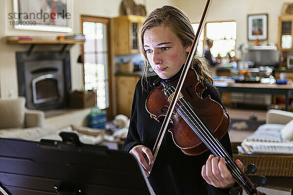 Teenager-Mädchen übt Geige zu Hause