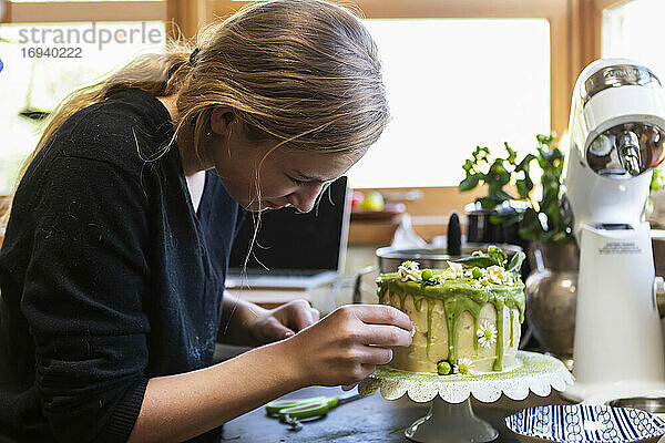 Teenager-Mädchen in der Küche Anwendung Zuckerguss auf Kuchen